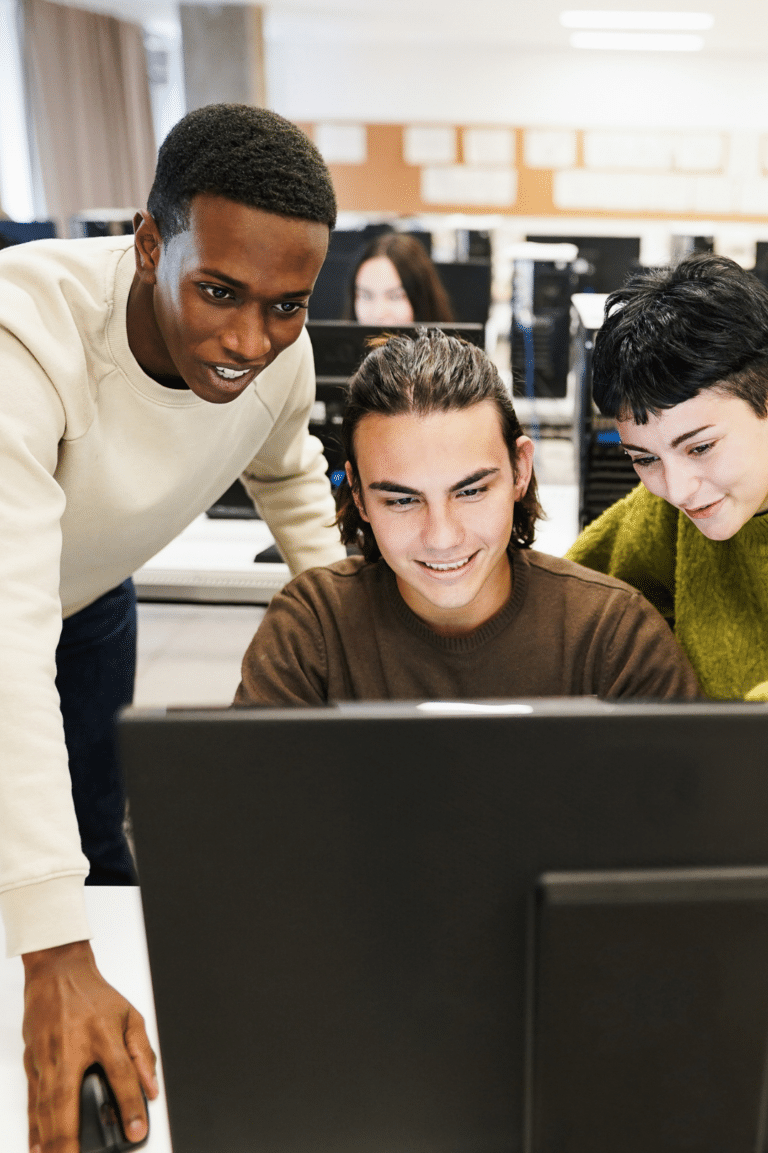 College students collaborating at computer in university lab - higher education communication systems